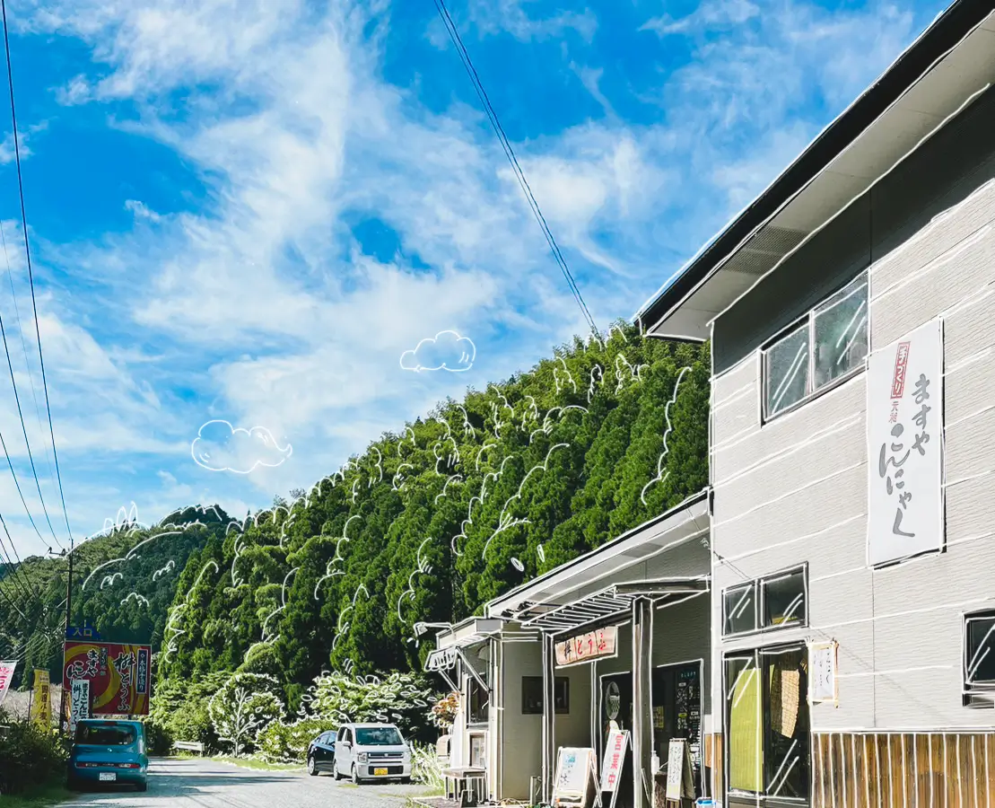 青空と杉の木が美しい景色。そこに構えるお店の外観